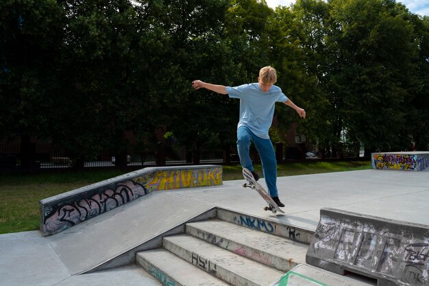 Teen doing trick on skateboard full shot