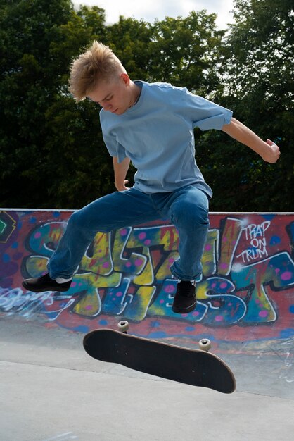 Teen doing trick on skateboard side view