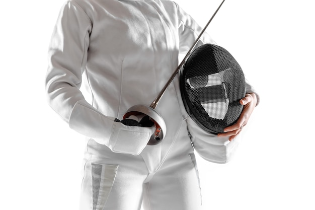 Teen girl in fencing costume with sword in hand isolated on white studio background.