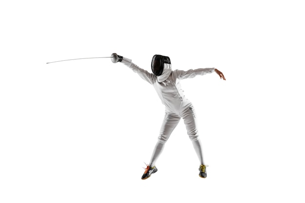 Teen girl in fencing costume with sword in hand isolated on white studio background.
