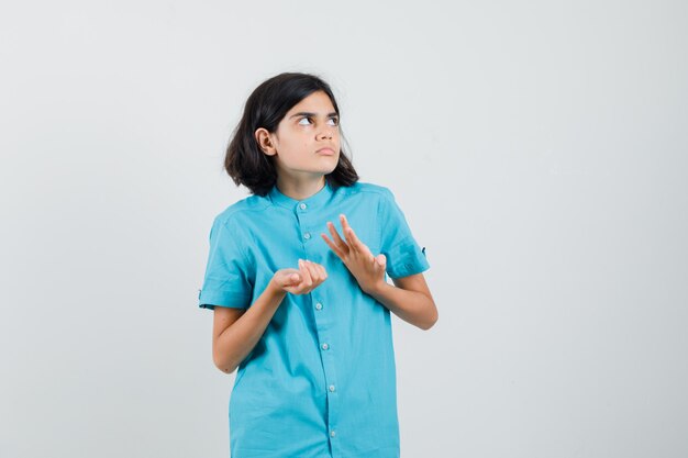 Teen girl getting into trouble in blue shirt and looking puzzled