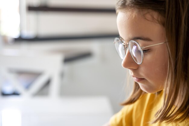 Teen girl in glasses on a blurred background closeup