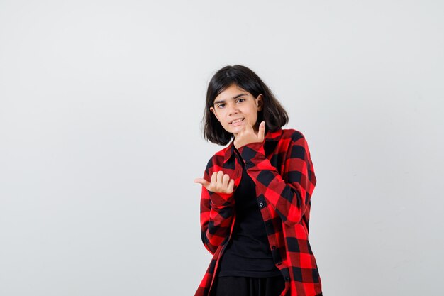 Teen girl inviting to come in casual shirt and looking merry. front view.