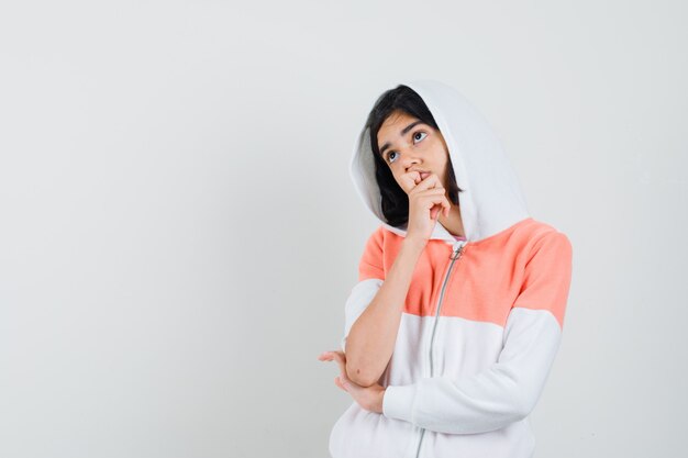 Teen girl looking away in sweatshirt and looking thoughtful.