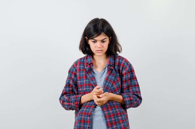 Teen girl looking down in casual clothes and looking downcast , front view.