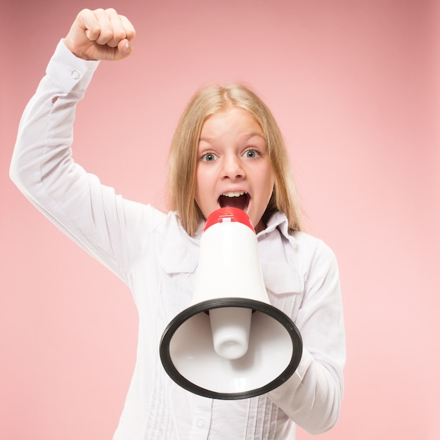 Free photo teen girl making announcement with megaphone at pink studio