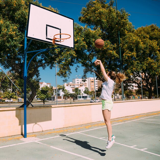Девушка играет в баскетбол на поле