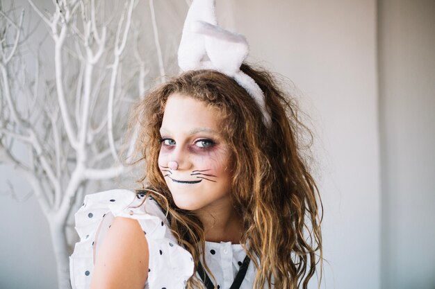 Teen girl posing in rabbit face paint