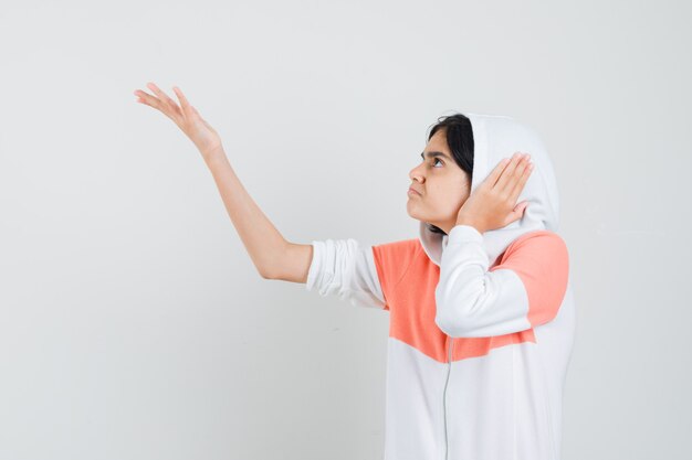 Teen girl protesting in white jacket and looking nervous.