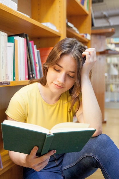 Teen girl reading in silent library