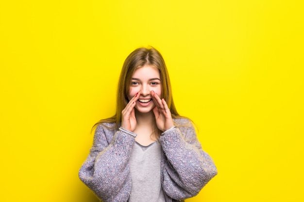 Free photo the teen girl shouts, having combined hands in a megaphone isolated