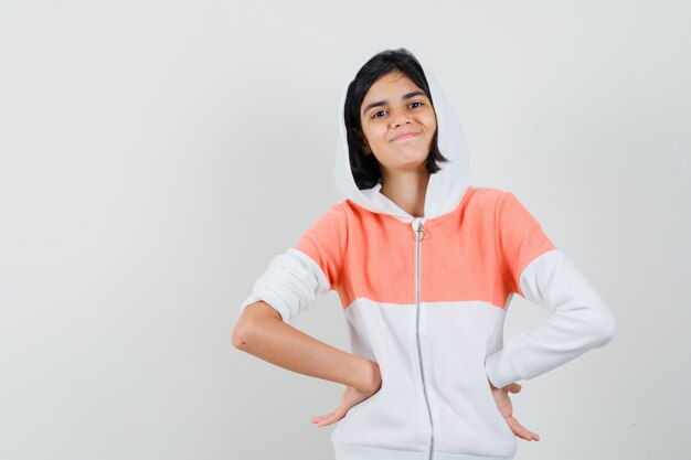 Teen girl in sweatshirt putting hands on her waist and looking self-satisfied.