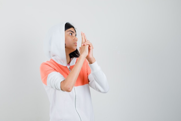 Teen girl in sweatshirt showing pistol sign and looking brave.