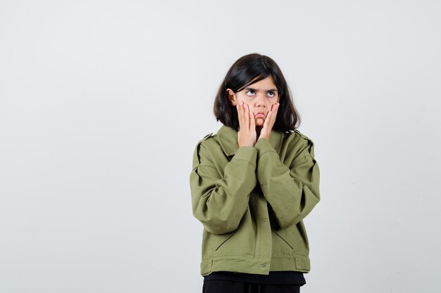 Teen girl in t-shirt, jacket pulling down her skin and looking bored , front view.