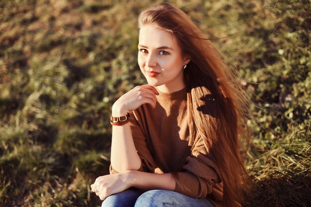 Teen girl with long hair sitting on the grass