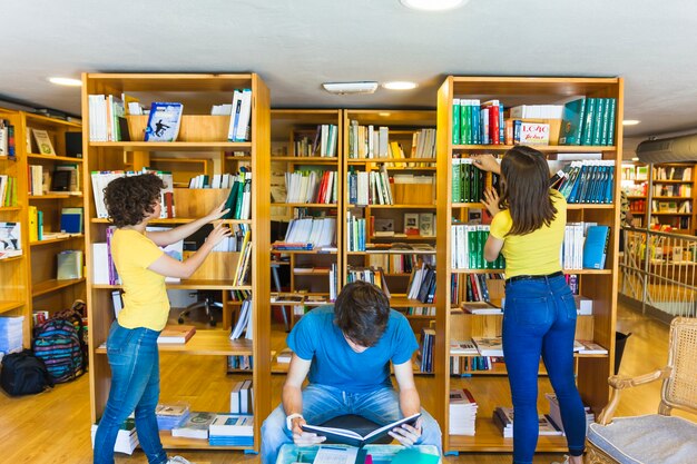 teen girls choosing books near reading friend