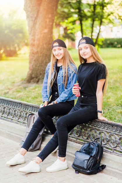 Девочки-подростки с напитками, смотрящими на камеру