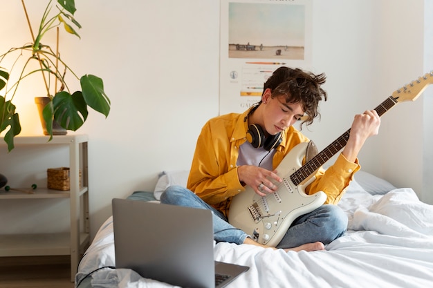 Teen making music at home front view