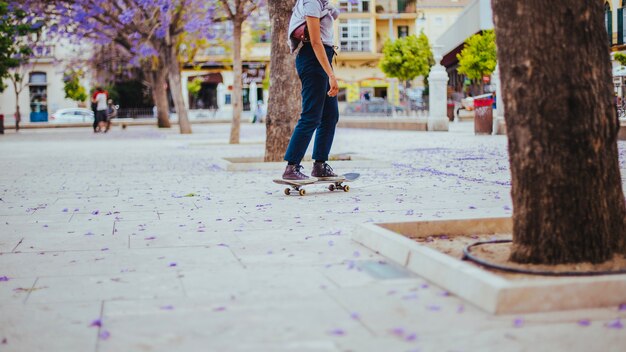 Teen riding skateboard on pavement