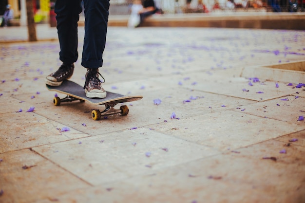 Teen riding skateboard on paving flag