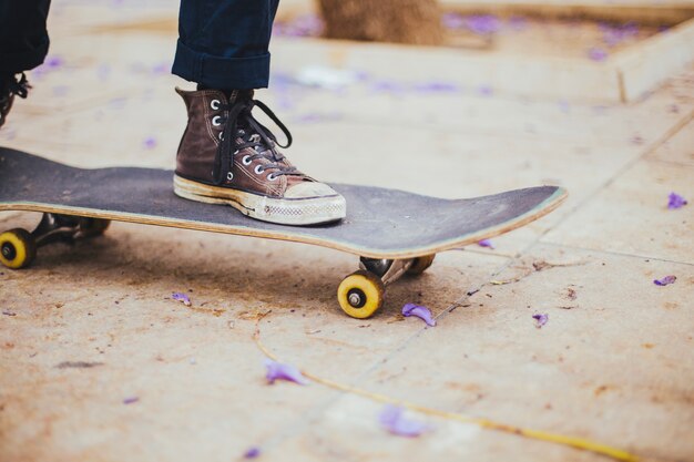 Teen riding skateboard on paving flag