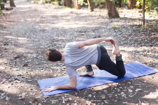 Teen with arm on the floor stretching his leg