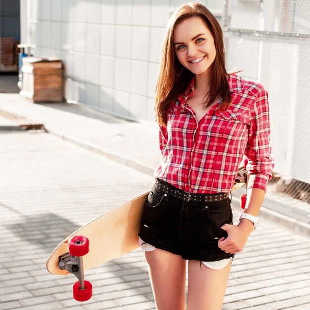 Teen with black shorts holding a skateboard