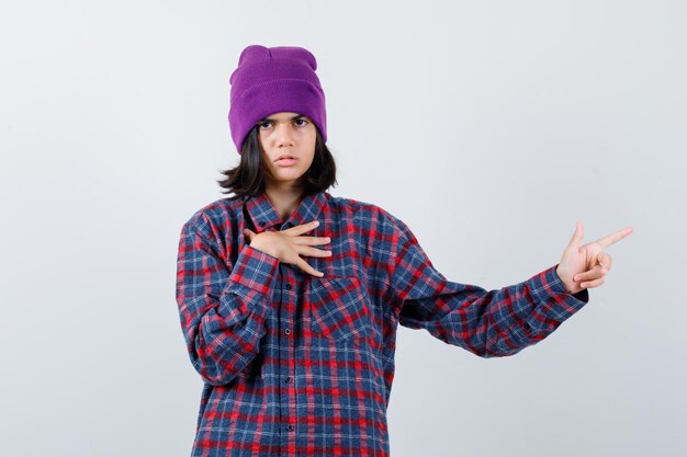 Подросток женщина в клетчатой рубашке и шапочке, жестикулируя изолированные