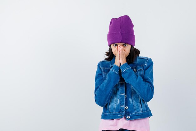 Teen woman in checkered shirt and beanie gesticulating isolated