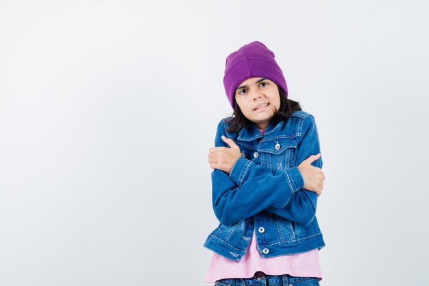 Teen woman in checkered shirt and beanie gesticulating isolated