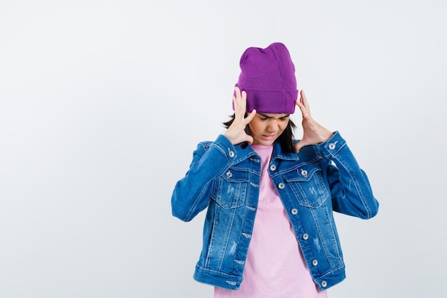 Teen woman in checkered shirt and beanie gesticulating isolated