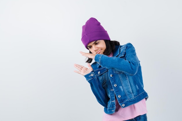 Free photo teen woman in checkered shirt and beanie gesticulating isolated