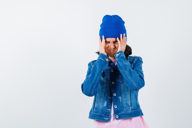 Teen woman in checkered shirt and beanie gesticulating isolated