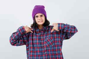 Foto gratuita teen donna in camicia a scacchi e berretto gesticolando isolato