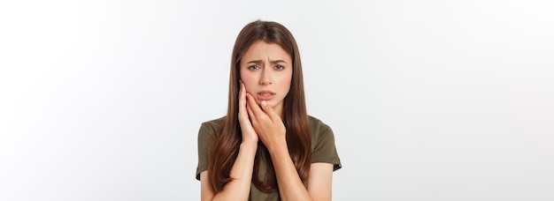 Teen woman pressing her bruised cheek with a painful expression as if she is having a terrible tooth