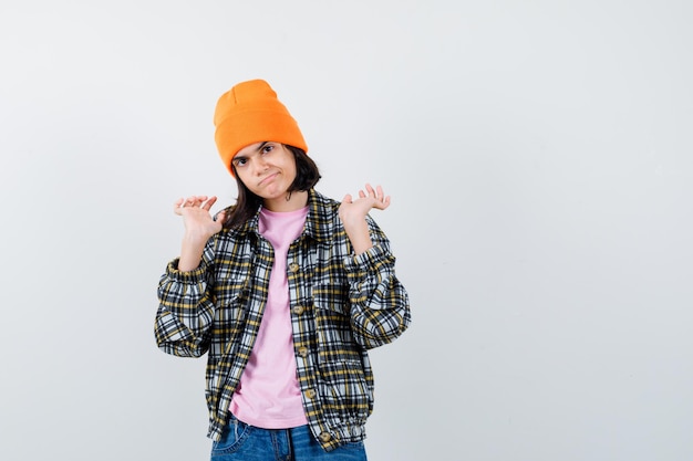 Teen woman raising hands in surrender gesture in t-shirt jacket looking dissatisfied