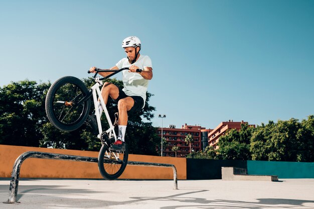 Teenage bmx rider performing tricks in skatepark