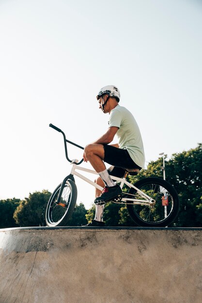 彼の自転車の低角度のビューで立っている10代のbmxライダー