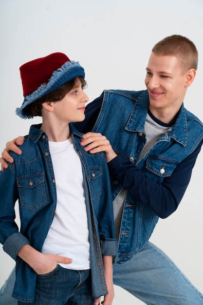 Free photo teenage boy and his younger brother wearing denim outfits together