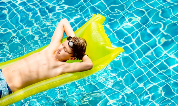 Foto gratuita adolescente che si distende con il materasso della piscina