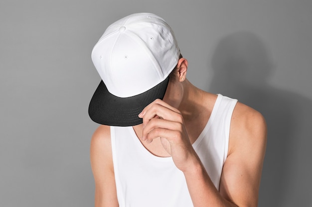 Free photo teenage boy in white snapback cap and tank top street fashion shoot