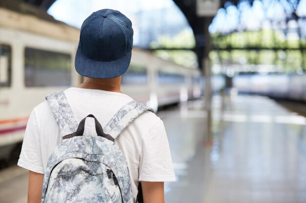 Teenage boy with backpack and wearing cap