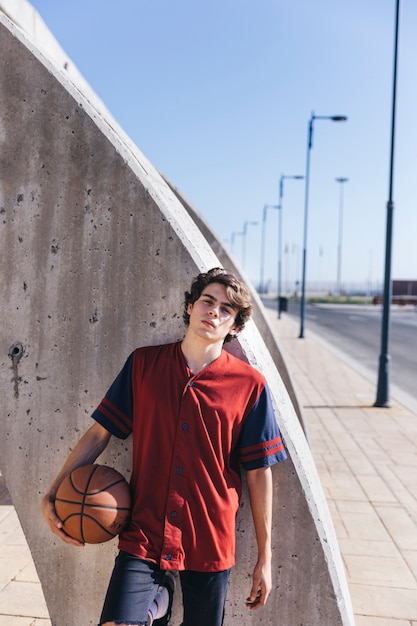 Foto gratuita adolescente con pallacanestro che guarda l'obbiettivo