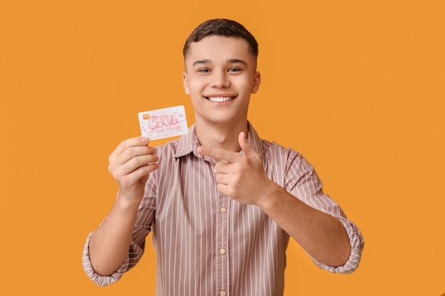 Teenage boy with gift card on color