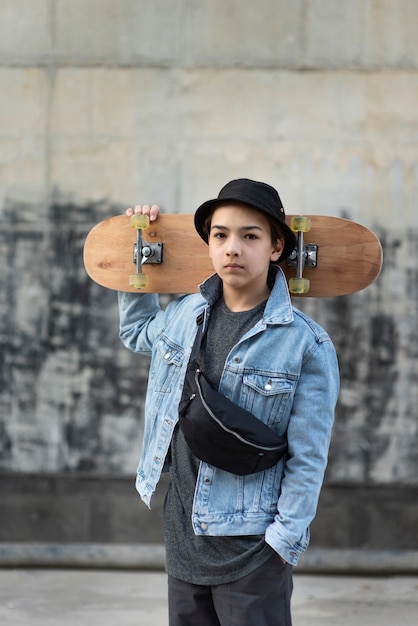 無料写真 スケートボードを持つ10代の少年