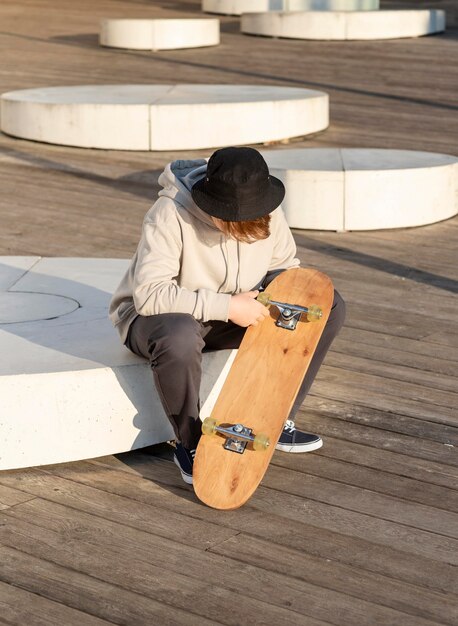 スケートボードを持つ10代の少年