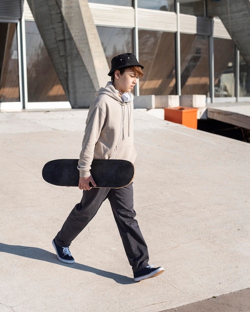 Free photo teenage boy with skateboard