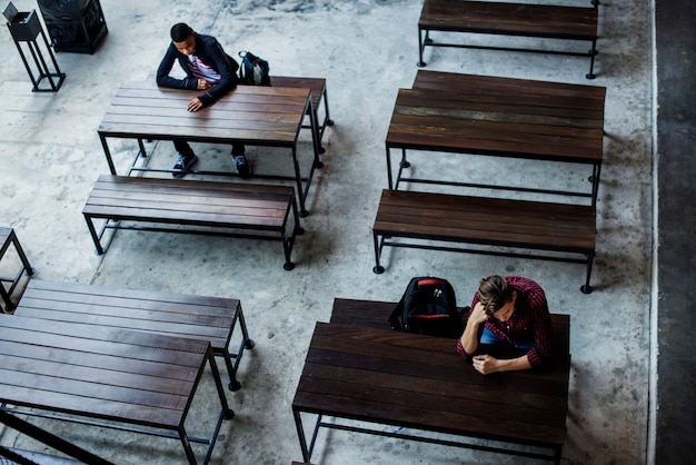 Teenage boys sitting by themselves in an empty canteen