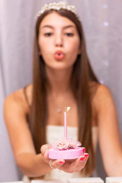 Teenage girl blowing on birthday candle