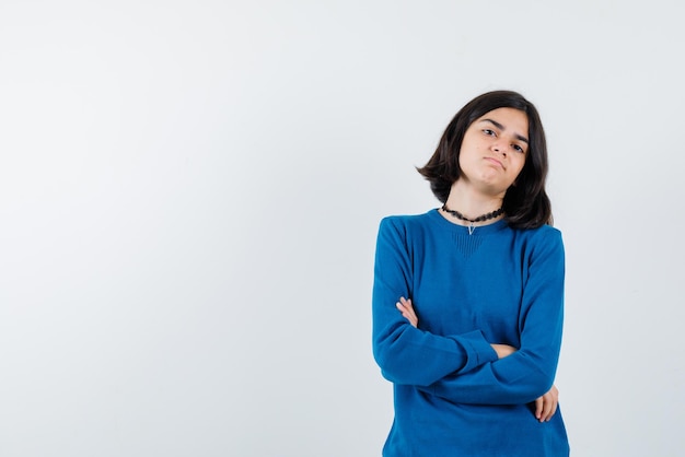 Teenage girl crossing her arms together on white background